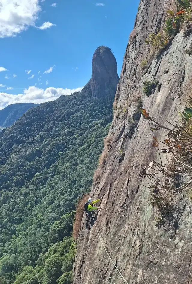 Escalador na grande parede da Pedra do Baú, com o Bauzinho ao fundo